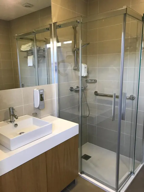 Une salle de bain moderne avec douche à l'italienne et vasque sur meuble.