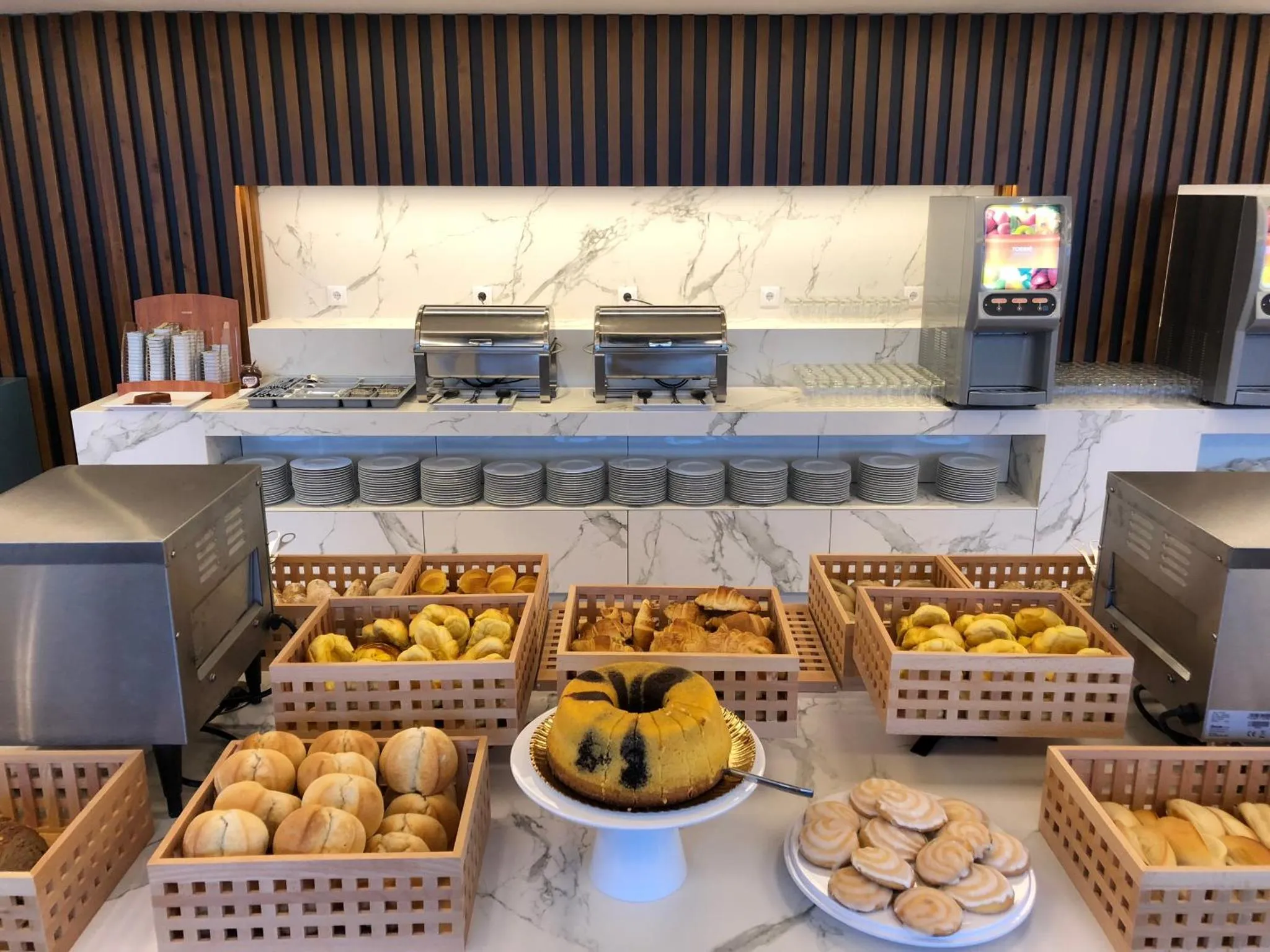 Un buffet propose une variété de viennoiseries et de pâtisseries.