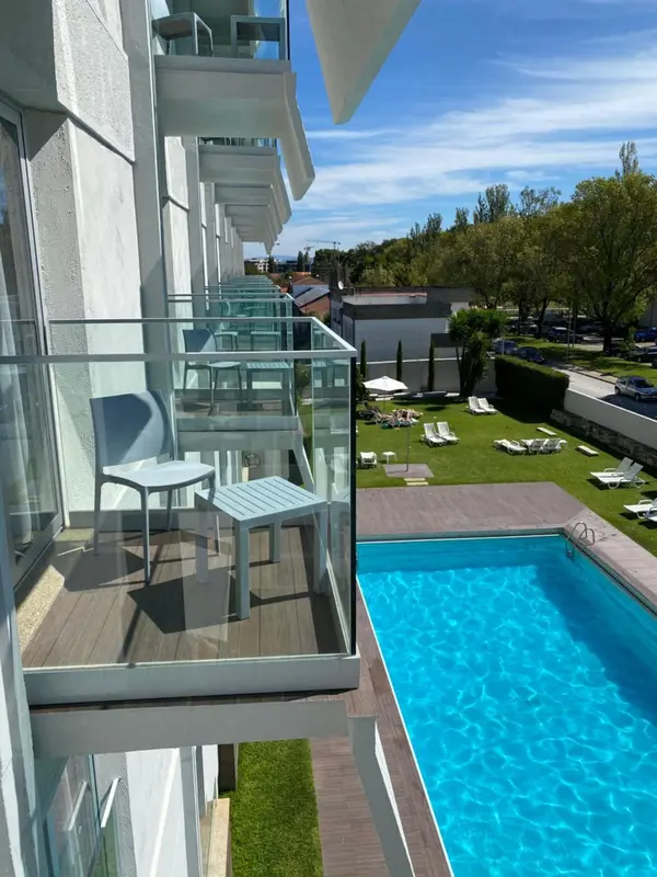 Terrasse avec mobilier d'extérieur surplombant une piscine et un jardin.