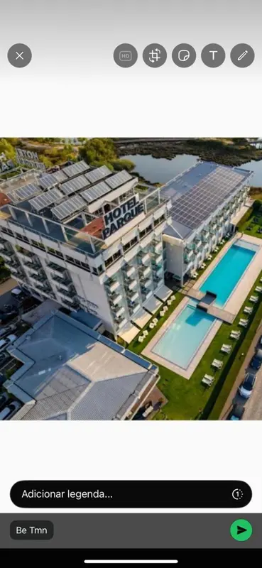 Vue aérienne d'un bâtiment moderne avec une piscine et des espaces verts.