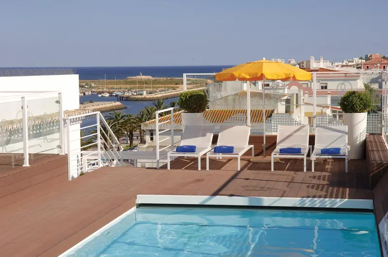 Terrasse avec transats et petite piscine face à la mer.