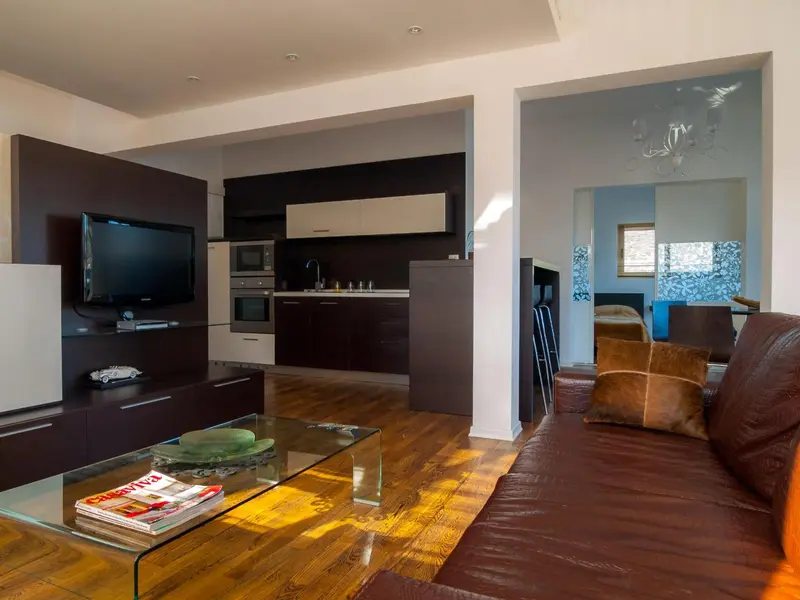 Un salon moderne avec canapé en cuir et table basse en verre.