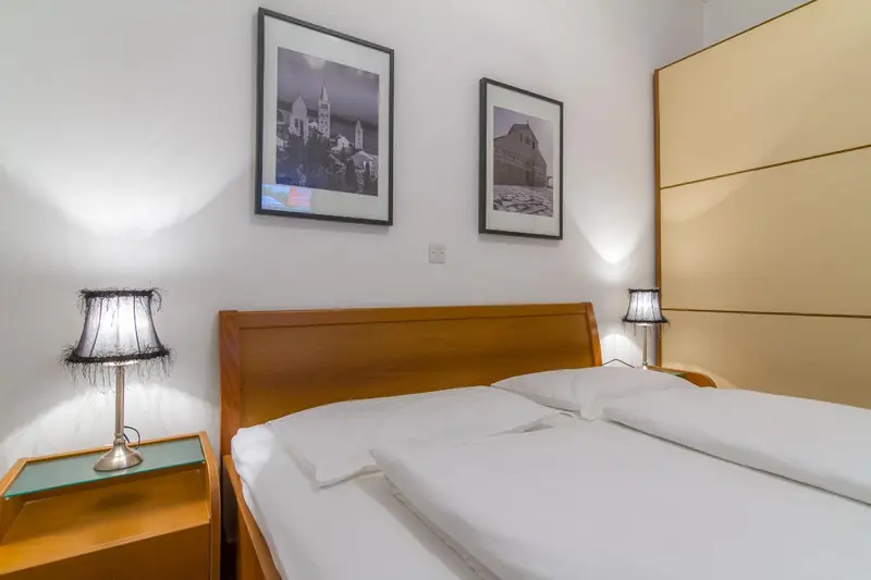 Une chambre lumineuse avec un grand lit et des tableaux décoratifs.