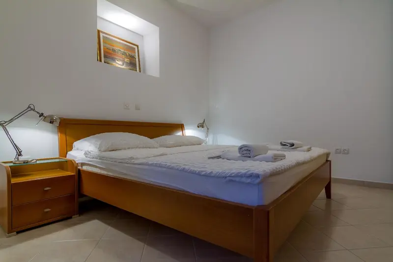 Une chambre lumineuse avec un lit double et des tables de chevet.