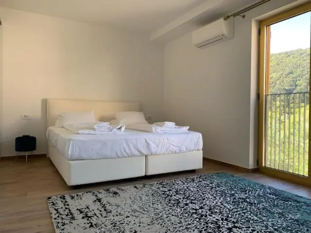 Une chambre lumineuse avec un grand lit et un accès à une terrasse.