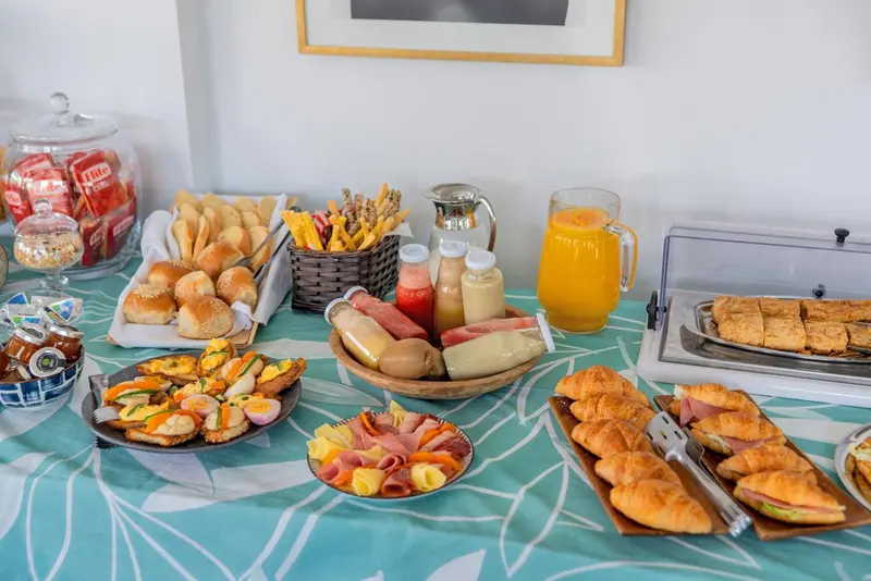 Un buffet propose une variété de viennoiseries, de charcuteries et de boissons.