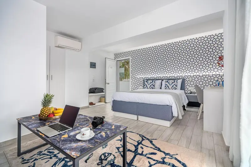Une chambre lumineuse avec un bureau et un lit fait.