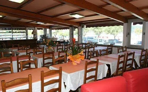 Une salle de restaurant lumineuse avec des tables nappées et un comptoir de boissons.