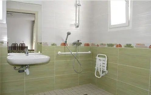 Une salle de bain claire avec douche et lavabo.