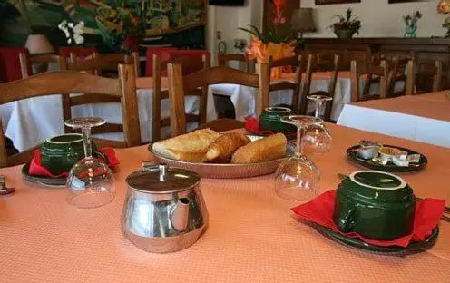 Une table est dressée avec des viennoiseries, du pain et du café.