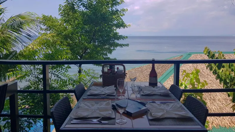 Table dressée sur une terrasse avec vue sur la mer.