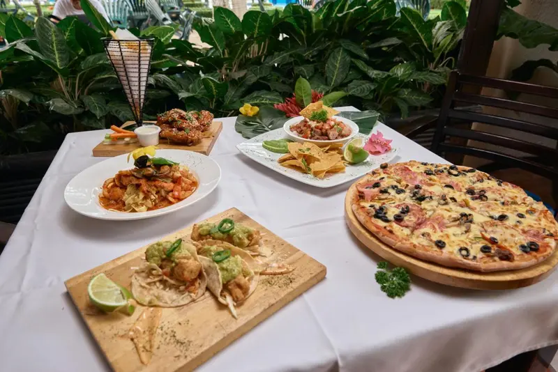 Une table dressée présente divers plats et une pizza.