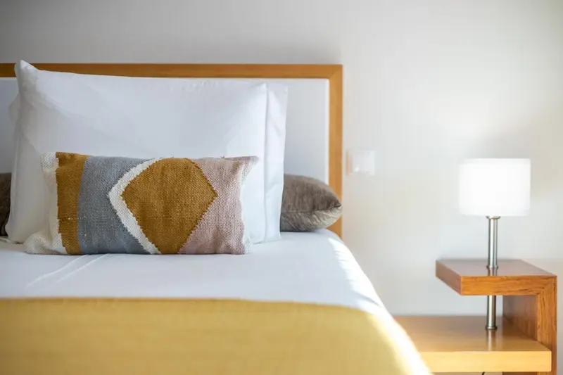 Un lit avec des oreillers et une couverture colorée dans une chambre.