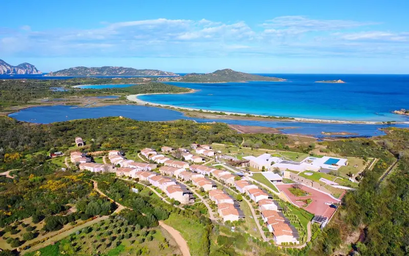 Vue aérienne d'un complexe hôtelier au bord de la mer et d'une plage de sable blanc.