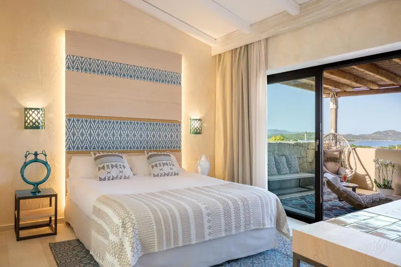 Une chambre lumineuse avec un grand lit et un accès à une terrasse.