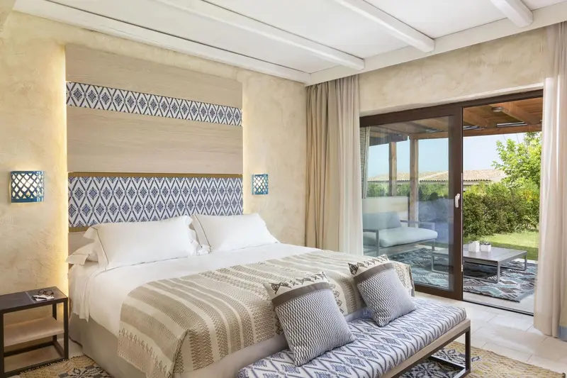 Une chambre lumineuse avec un grand lit et un accès à une terrasse.