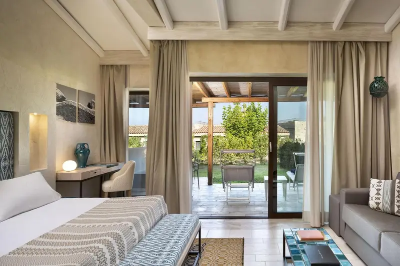 Une chambre lumineuse s'ouvre sur une terrasse avec mobilier.