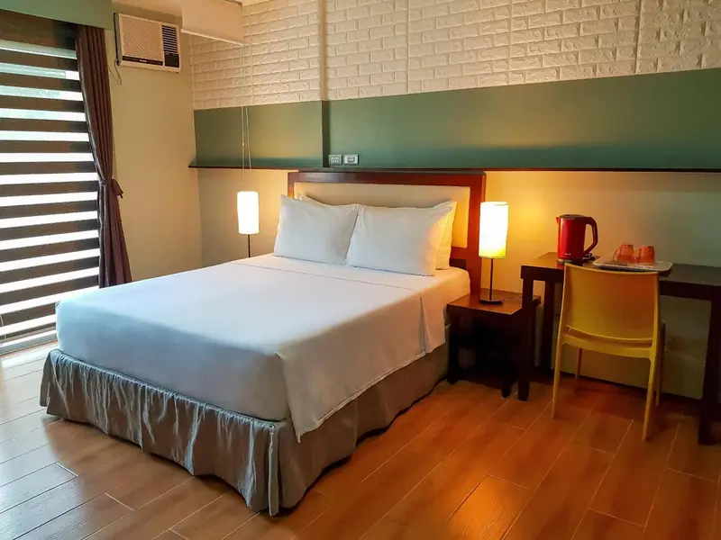 Une chambre lumineuse avec un grand lit et une table de chevet.