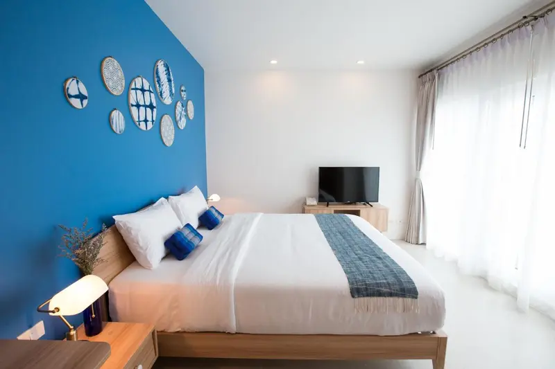 Une chambre lumineuse avec un lit double et une décoration murale.