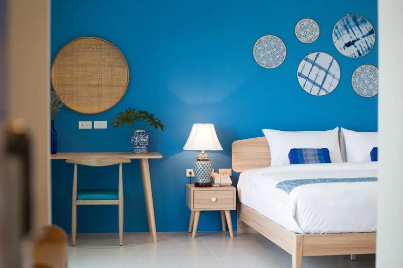 Une chambre lumineuse avec un lit blanc et des éléments de décoration murale.