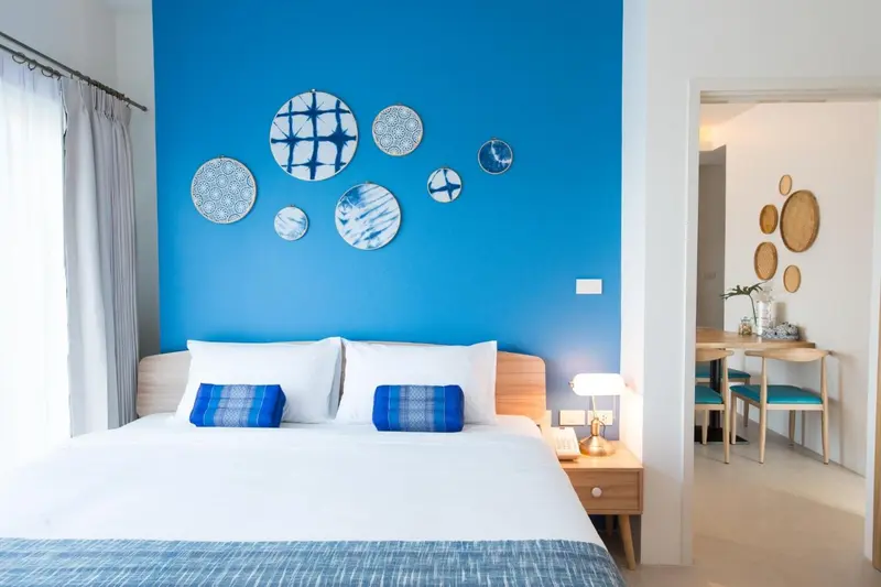 Une chambre lumineuse avec un grand lit et une décoration murale originale.