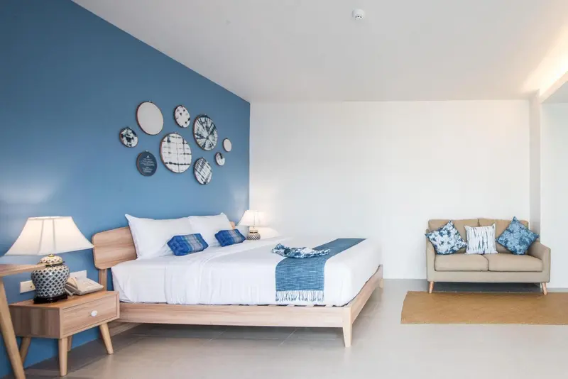 Une chambre lumineuse avec un grand lit et un canapé.