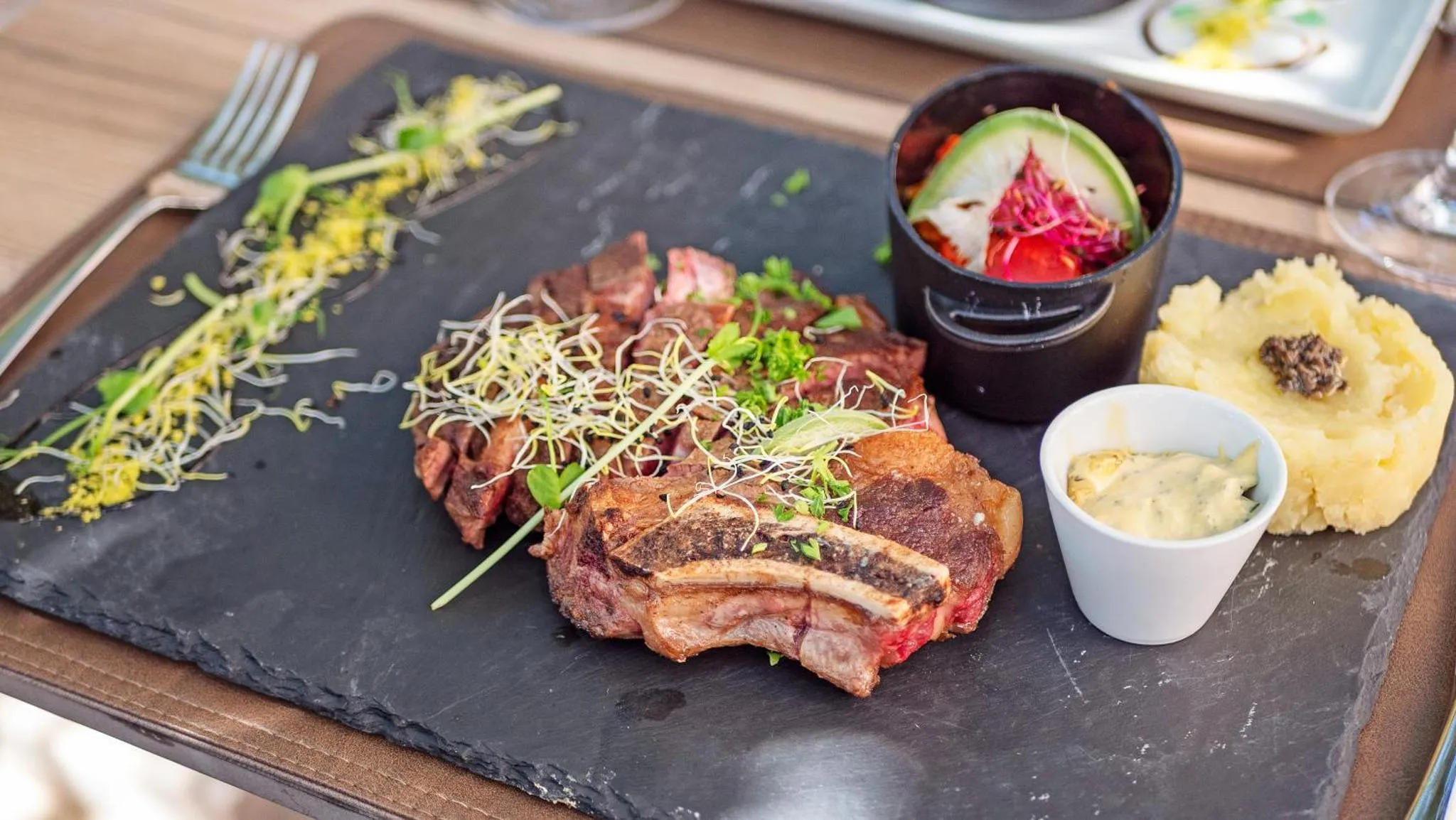 Assiette de viande grillée accompagnée de légumes et de purée.