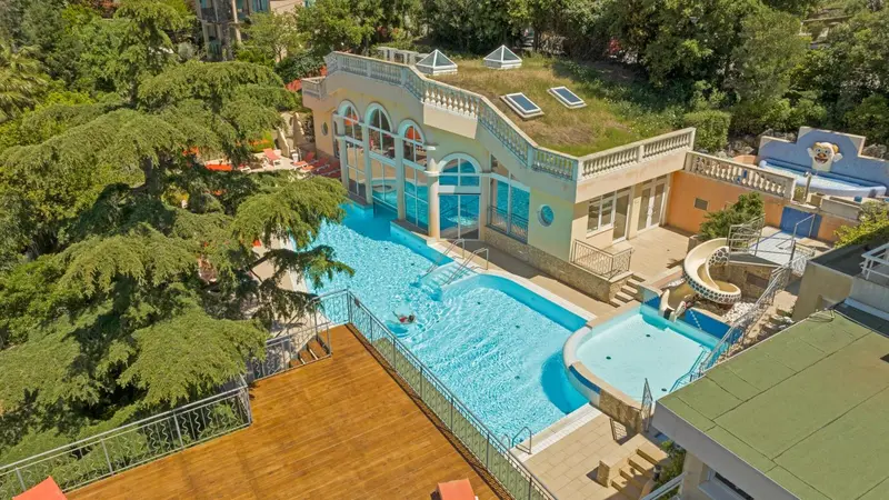Vue aérienne d'un complexe hôtelier avec piscine et toboggan.