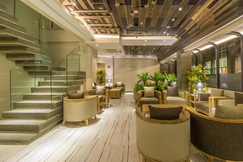 Espace de détente intérieur avec canapés et plantes vertes.