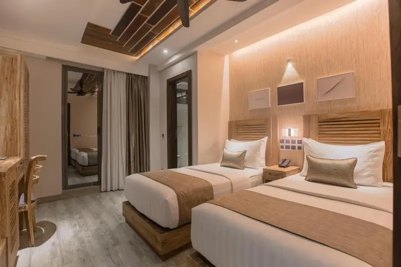 Chambre avec deux lits simples et décoration en bois.