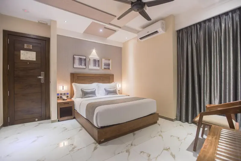 Une chambre lumineuse avec un grand lit et une décoration sobre.