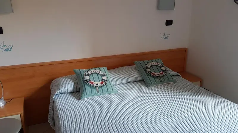Une chambre lumineuse avec un lit recouvert d'une couette à motifs.