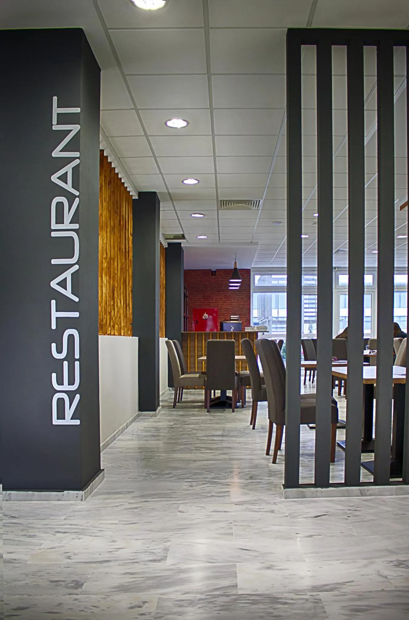 Une salle de restaurant lumineuse avec des tables et des chaises.