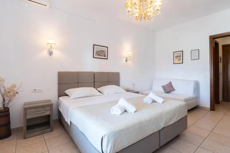 Une chambre lumineuse avec un grand lit et des tables de chevet.