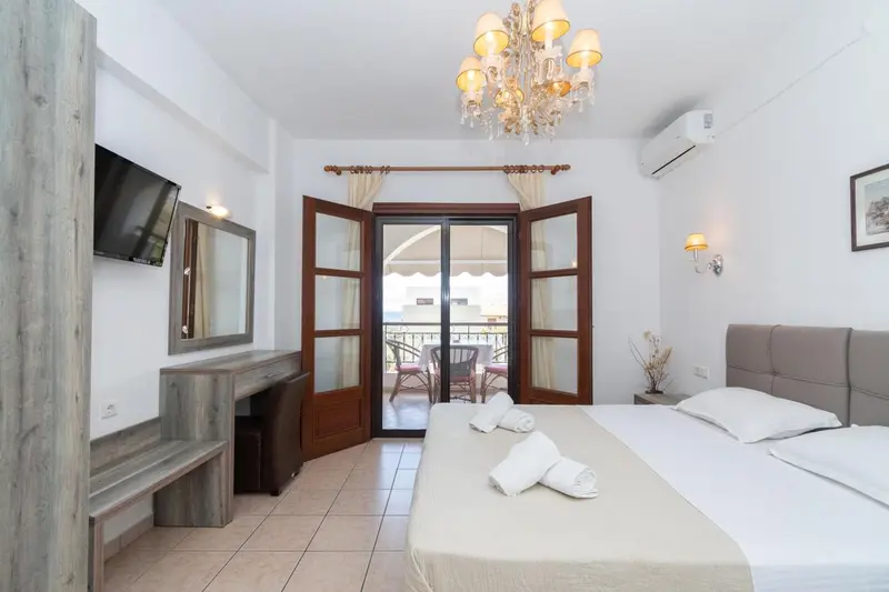 Une chambre lumineuse avec un grand lit et un accès à un balcon.