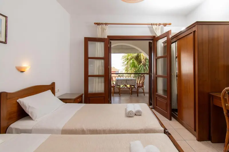 Une chambre lumineuse avec un lit et un accès à une terrasse.