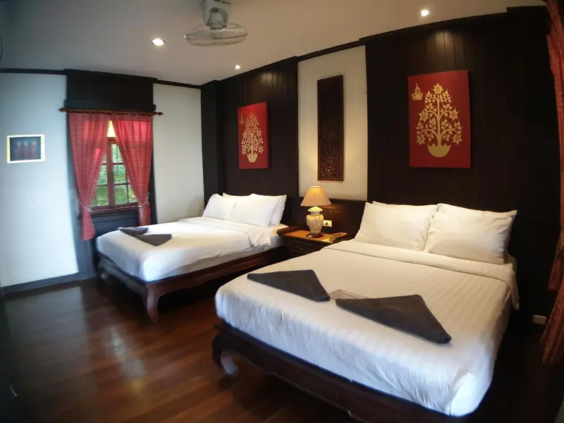 Chambre avec deux lits simples et décoration murale.
