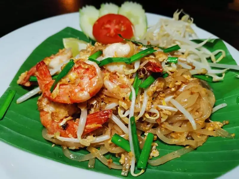 Assiette de nouilles sautées aux crevettes et aux légumes.