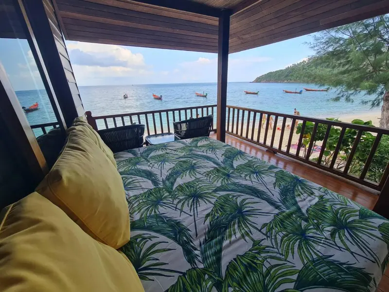 Espace de détente extérieur avec vue sur la mer et des embarcations.