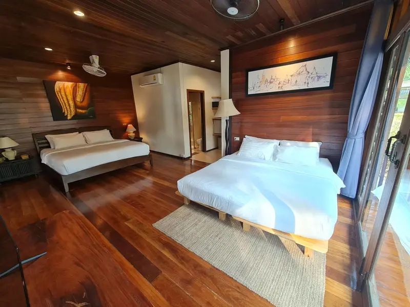 Une chambre spacieuse avec deux lits et une décoration en bois.