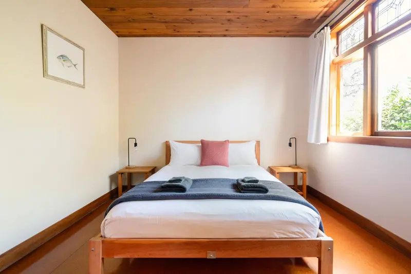 Une chambre lumineuse avec un lit double et des tables de chevet.