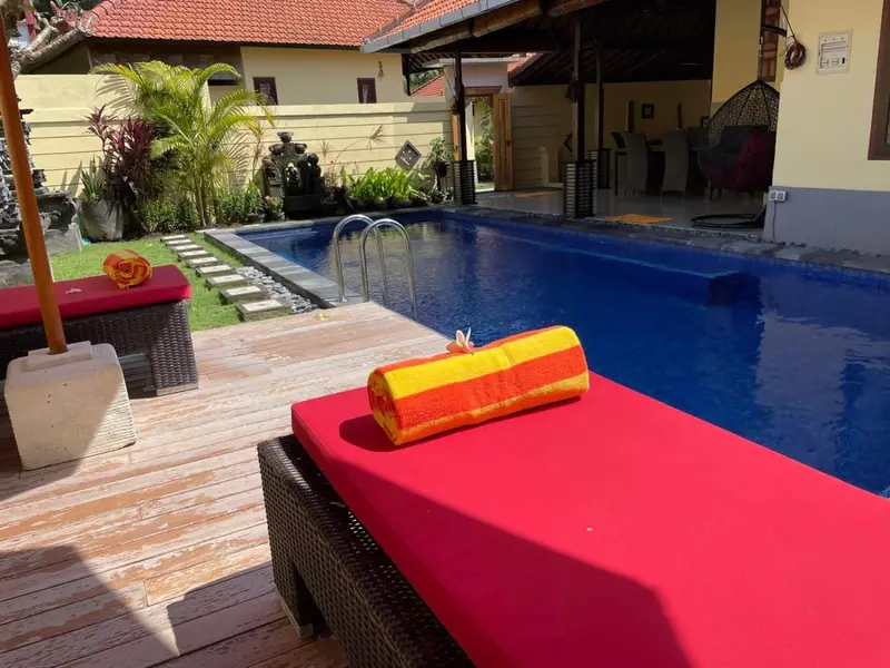 Transats colorés au bord d'une piscine ensoleillée.