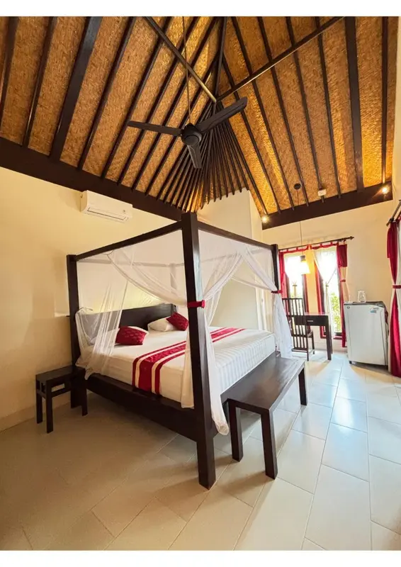 Une chambre avec un lit à baldaquin et une décoration sobre.