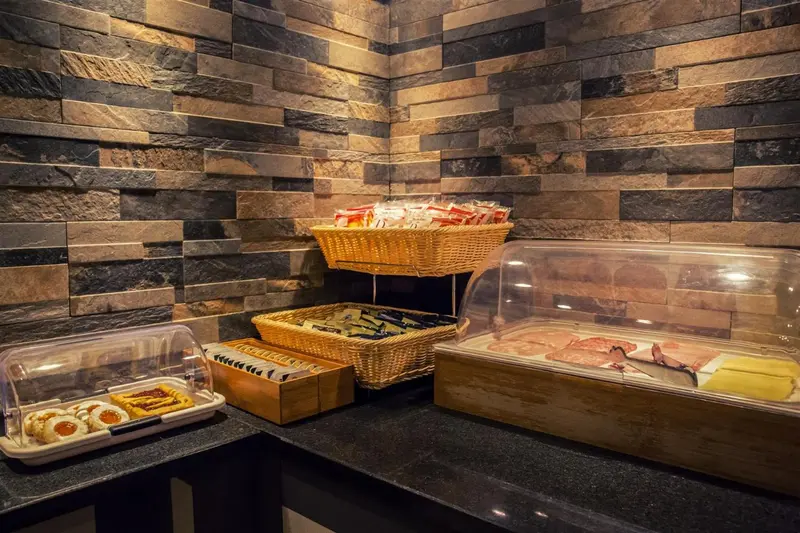 Présentation de viennoiseries et de charcuterie sur un comptoir noir.