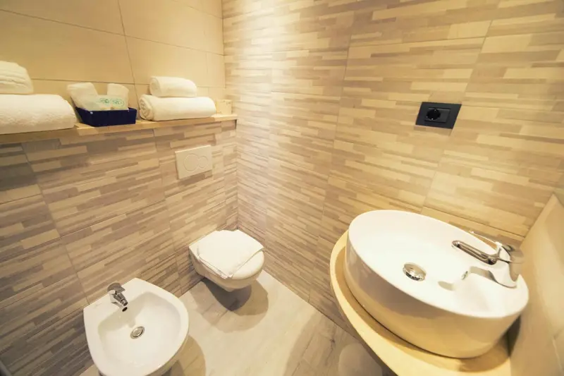 Une salle de bain moderne avec des serviettes pliées et des sanitaires blancs.