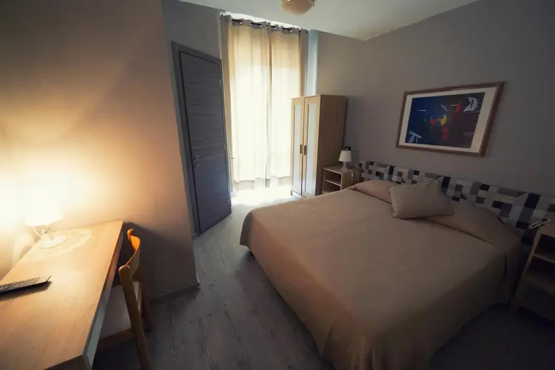 Une chambre lumineuse avec un lit et un bureau.