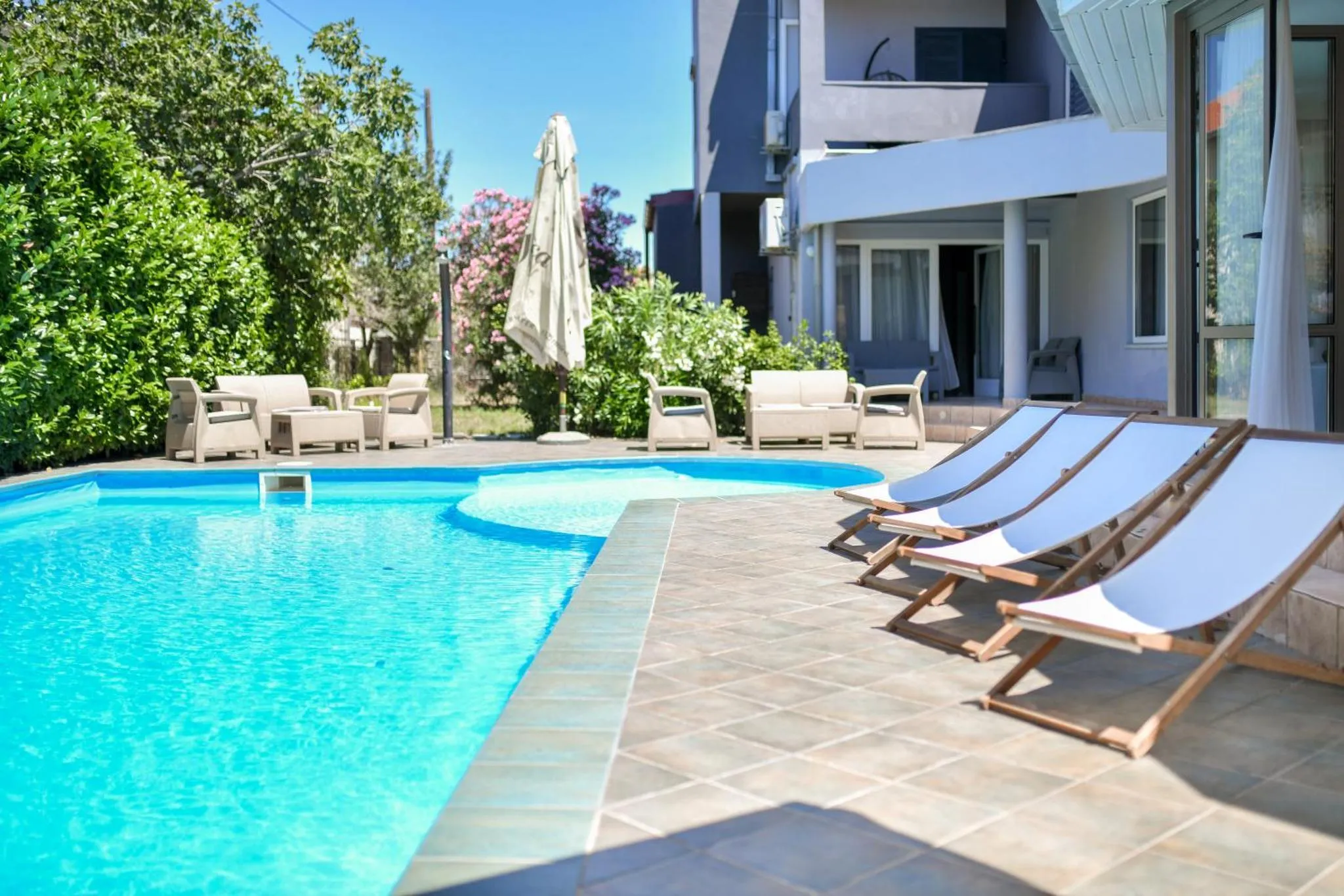 Transats alignés au bord d'une piscine ensoleillée.