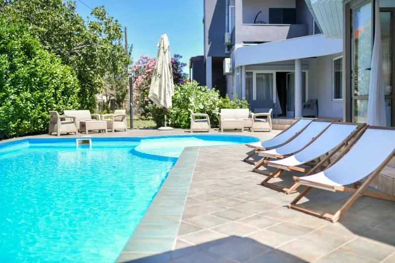Transats alignés au bord d'une piscine ensoleillée.