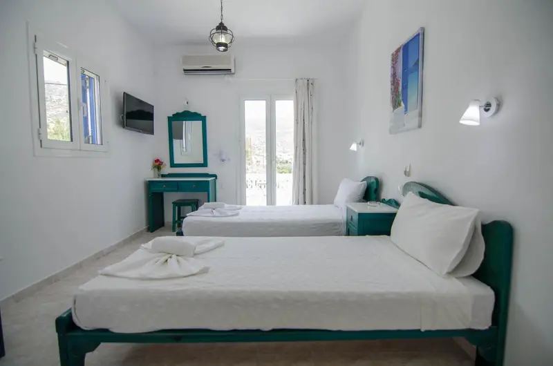 Une chambre lumineuse avec deux lits simples et une décoration sobre.
