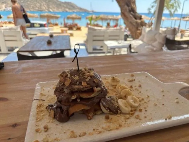 Un dessert au chocolat et aux fruits est présenté sur une table en bois.